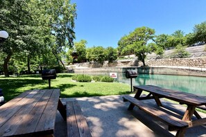 Ein Außenbereich mit Picknicktischen, einem Grill und einem Swimmingpool.