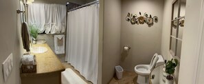 A bathroom with a sink, toilet, and shower curtain.
