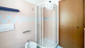 Un baño con cabina de ducha, un bidé y un inodoro.