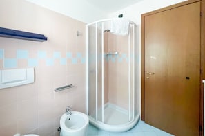 Ein Badezimmer mit Duschkabine, Bidet und Toilette.