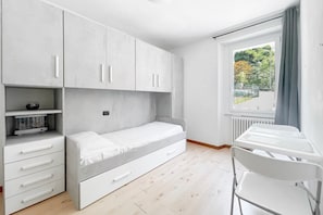 A compact bedroom with a bed, a desk, and a chair. - BLUE HOUSE 1 by Design Studio (Bellano)