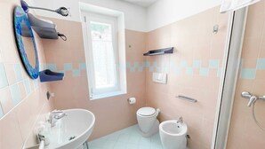 A bathroom with a sink, toilet, bidet, and shower. - BLUE HOUSE 1 by Design Studio (Bellano)