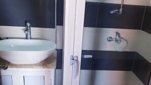A bathroom with a white sink, a mirror, and a shower area with black and white tiles. - High standing apartment in Guéliz 2 minutes from Carre Eden (Marrakech)