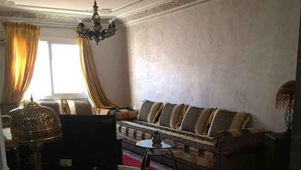 A living room with a sofa, a TV, a lamp, and a decorative ceiling. - High standing apartment in Guéliz 2 minutes from Carre Eden (Marrakech)