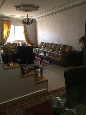 A living room with a sofa, a TV, a lamp, and a decorative ceiling. - High standing apartment in Guéliz 2 minutes from Carre Eden (Marrakech)