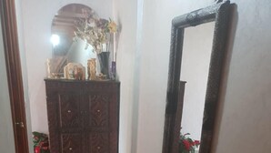 A hallway with a wooden cabinet, a mirror, and a red patterned rug. - High standing apartment in Guéliz 2 minutes from Carre Eden (Marrakech)
