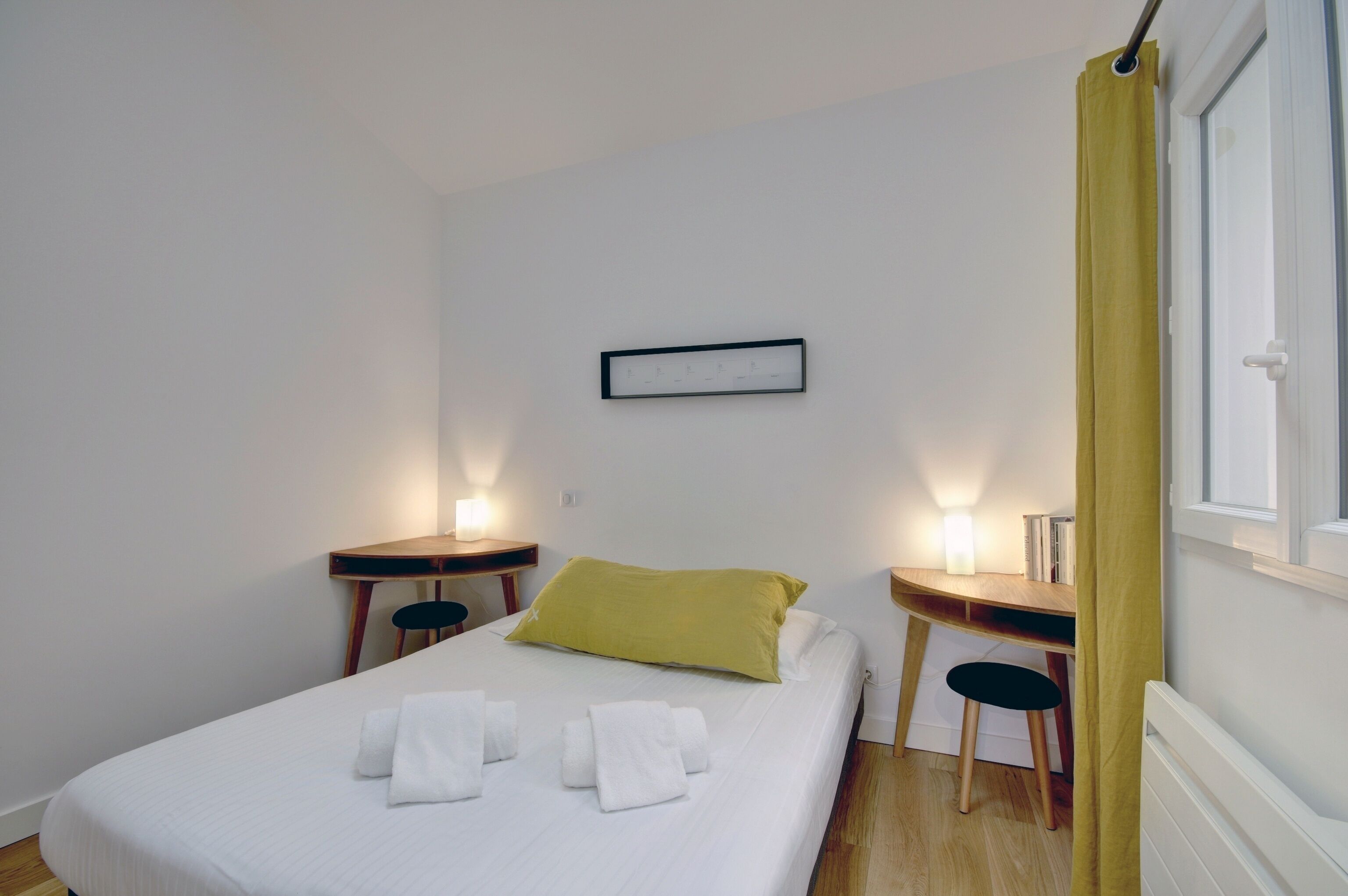 Ett hotellrum med en säng, ett skrivbord och en stol.