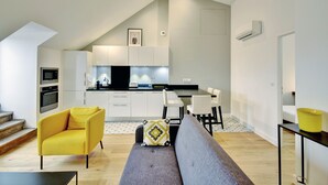 A modern apartment with a kitchen, dining area, and living room.