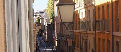 A street view with buildings, a clear sky, and a pedestrian walkway.