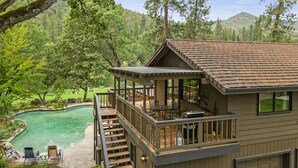 A two-story house with a deck, a pool, and a garage.
