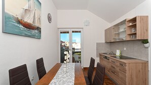 Une cuisine moderne avec des meubles en bois, un évier encastré et un coin repas comprenant une longue table et des chaises.