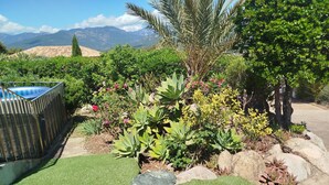 A landscaped garden with artificial grass, various plants, and a pool. - APARTMENT T3 PROCHE PINARELLO VUE AIGUILLES BAVELLA - SWIMMING POOL AND SPA (sainte-lucie de porto-vecchio)