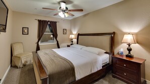 A hotel room with a large bed, a ceiling fan, a window with curtains, a bedside table with a lamp, and a chair. - ***3200 Sq Ft 5 Bed 4 Bath 1 Story Private Pool/Spa W/ Casita (Las Vegas)