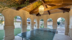 A ping pong table under a covered area with stone pillars and a hanging light fixture. - ***3200 Sq Ft 5 Bed 4 Bath 1 Story Private Pool/Spa W/ Casita (Las Vegas)