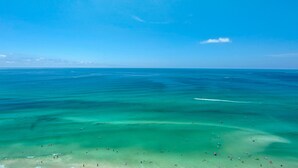 A beach with clear turquoise waters and a sandy shore.
