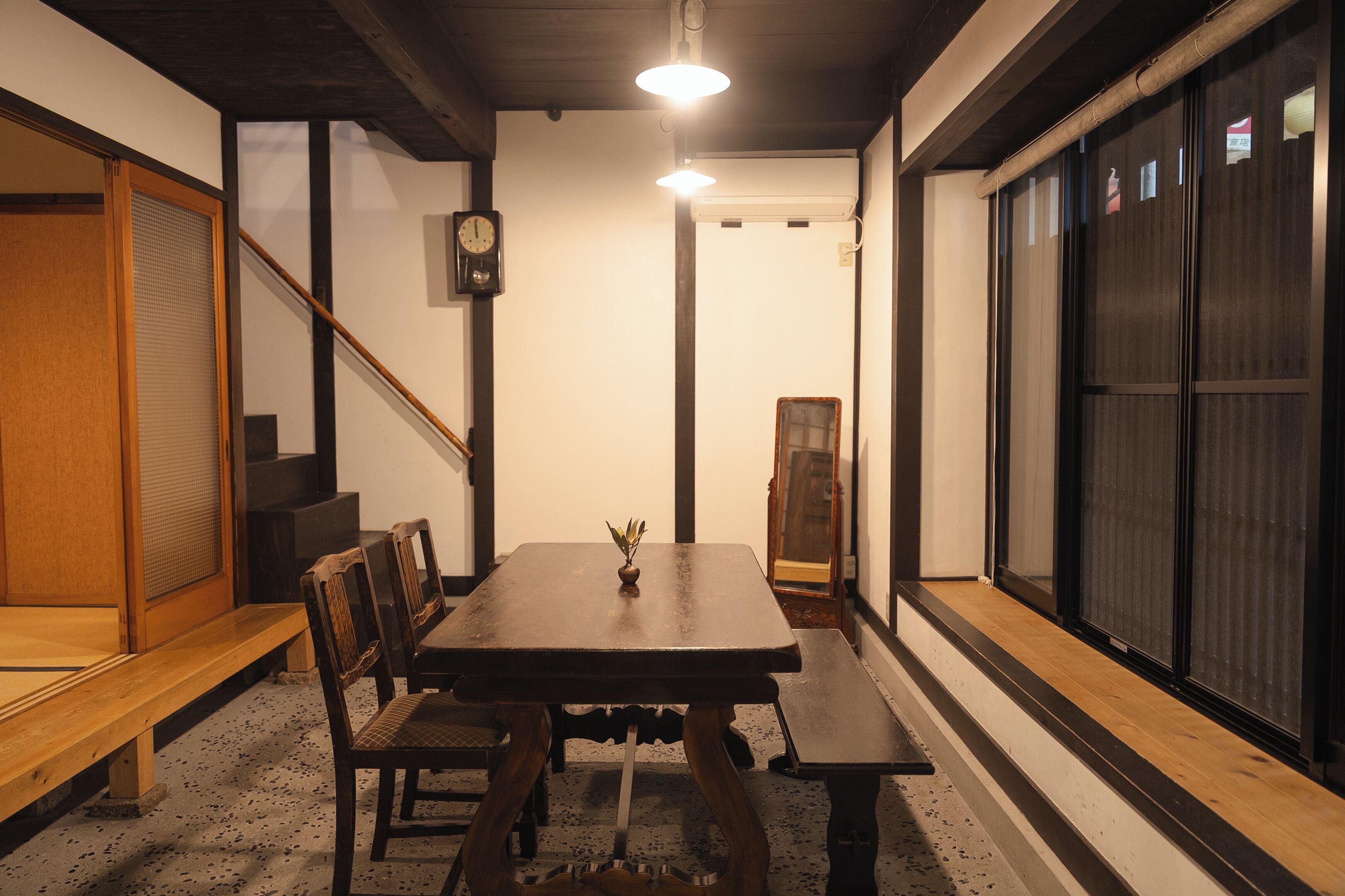 A traditional Japanese room with tatami flooring, a low wooden table, and sliding doors.