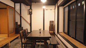 A traditional Japanese room with tatami flooring, a low wooden table, and sliding doors.