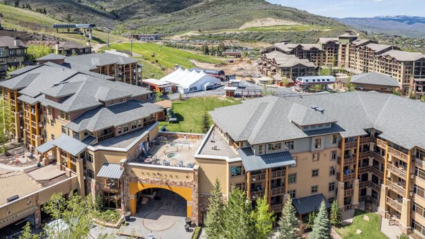 A resort with multiple buildings, a central courtyard, and a mountainous backdrop. - SUNDIAL LODGE PC~ PERFECT MT VILLAGE VIEW~ 5 STAR BY GUEST ~ PREMIUM  LOCATION! (Park City)