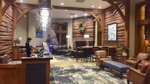A lobby with a wooden interior, a Christmas tree, leather seating, and a reception desk. - SUNDIAL LODGE PC~ PERFECT MT VILLAGE VIEW~ 5 STAR BY GUEST ~ PREMIUM  LOCATION! (Park City)