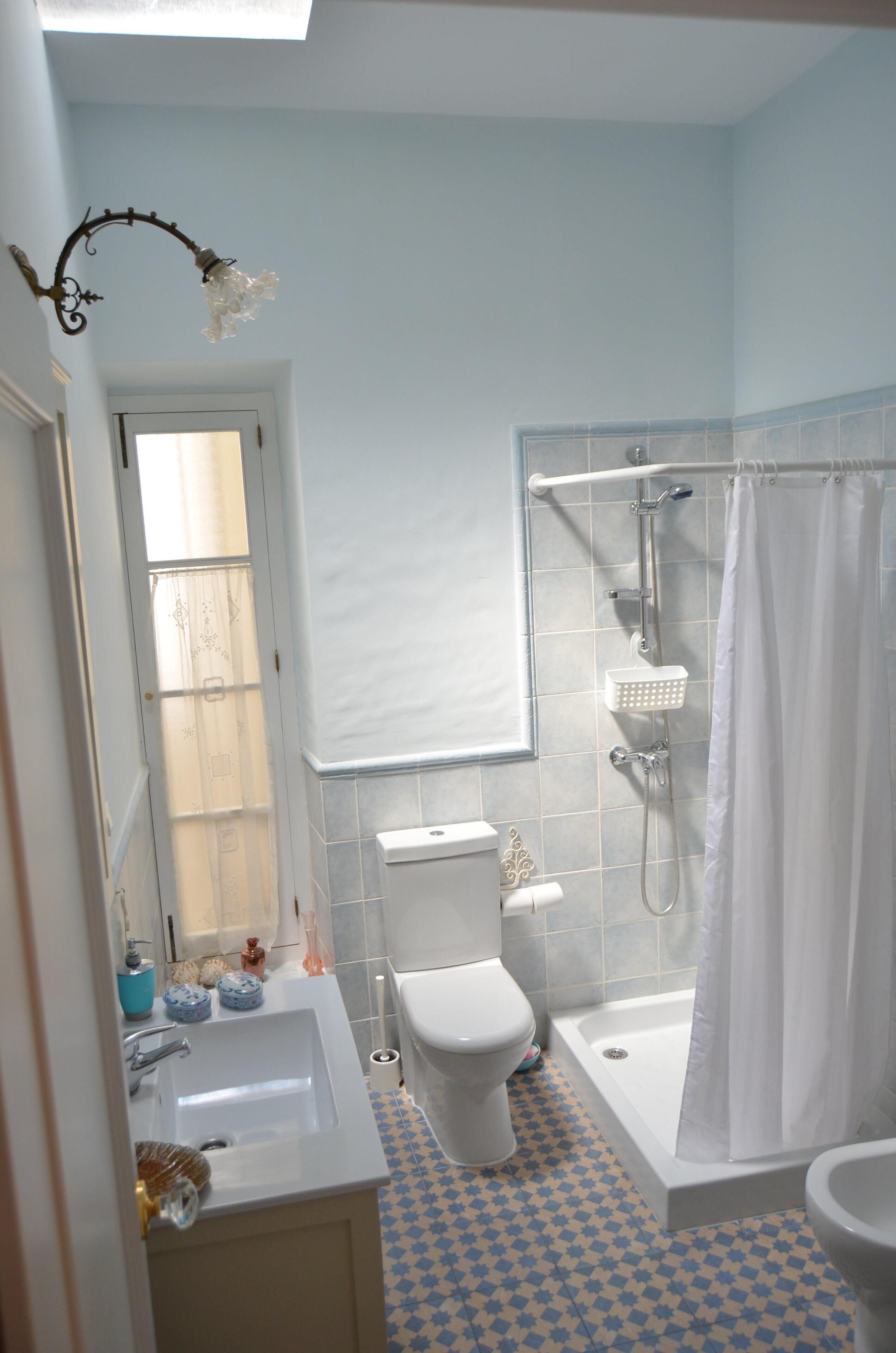 Un baño con inodoro blanco, lavamanos, bañera y ducha.