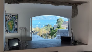 Una habitación con vistas al mar, un mapa en la pared y un escritorio con una computadora portátil y un vaso.