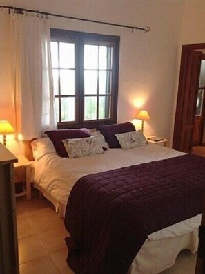 A bedroom with a bed, two bedside tables, a window, and a door. - House and garden terraces, fabulous sea and mountain views. Betlem (Betlem arta)