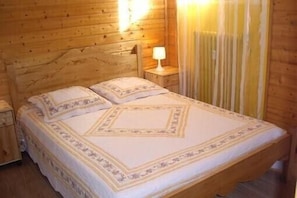 Cozy retreat with a neatly made bed and a bedside table with a lamp.