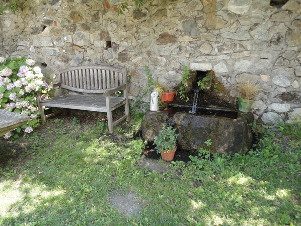 A stone wall, a wooden bench, a small water feature, and potted plants. - Renovated 15S farmhouse with swimming pool 10mx5m in full nature calm unique frame guaranteed (Céret)