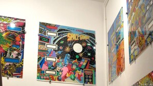 Ein Zimmer mit weißer Wand, verziert mit farbenfroher Weltraumkunst.