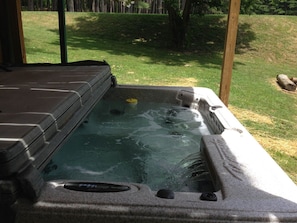 A hot tub with a stone exterior, a built-in seat, and a small waterfall feature. - Secluded Getaway in Nature, close to Hocking Hills (Hocking Hills)