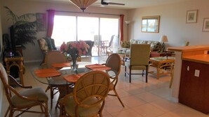 A dining area with a glass table, wicker chairs, and a vase of flowers. - Waterfront Condo with an amazing view - Pet Friendly (Indian Shores)