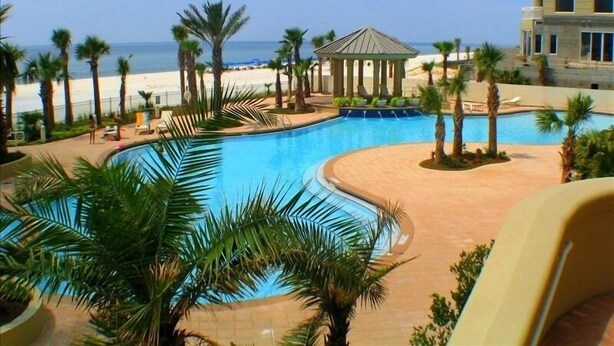 A swimming pool with a gazebo, palm trees, and a beach view. - Indigo 504E BeachFront!Bonus Den,Best View&Amenities HUGE Pool!HotTub Pickleball (Pensacola)