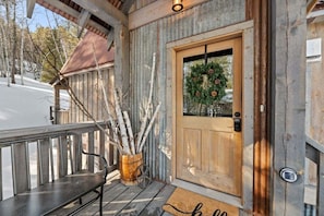 A wooden cabin with a wooden door, a bench, and a wreath on the door. - Raven`s Ridge - Access to Pool (Lead)