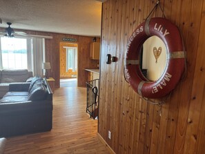 Un interior de madera con un sofá, un flotador salvavidas y un letrero que dice 'BEACH ROAD'.