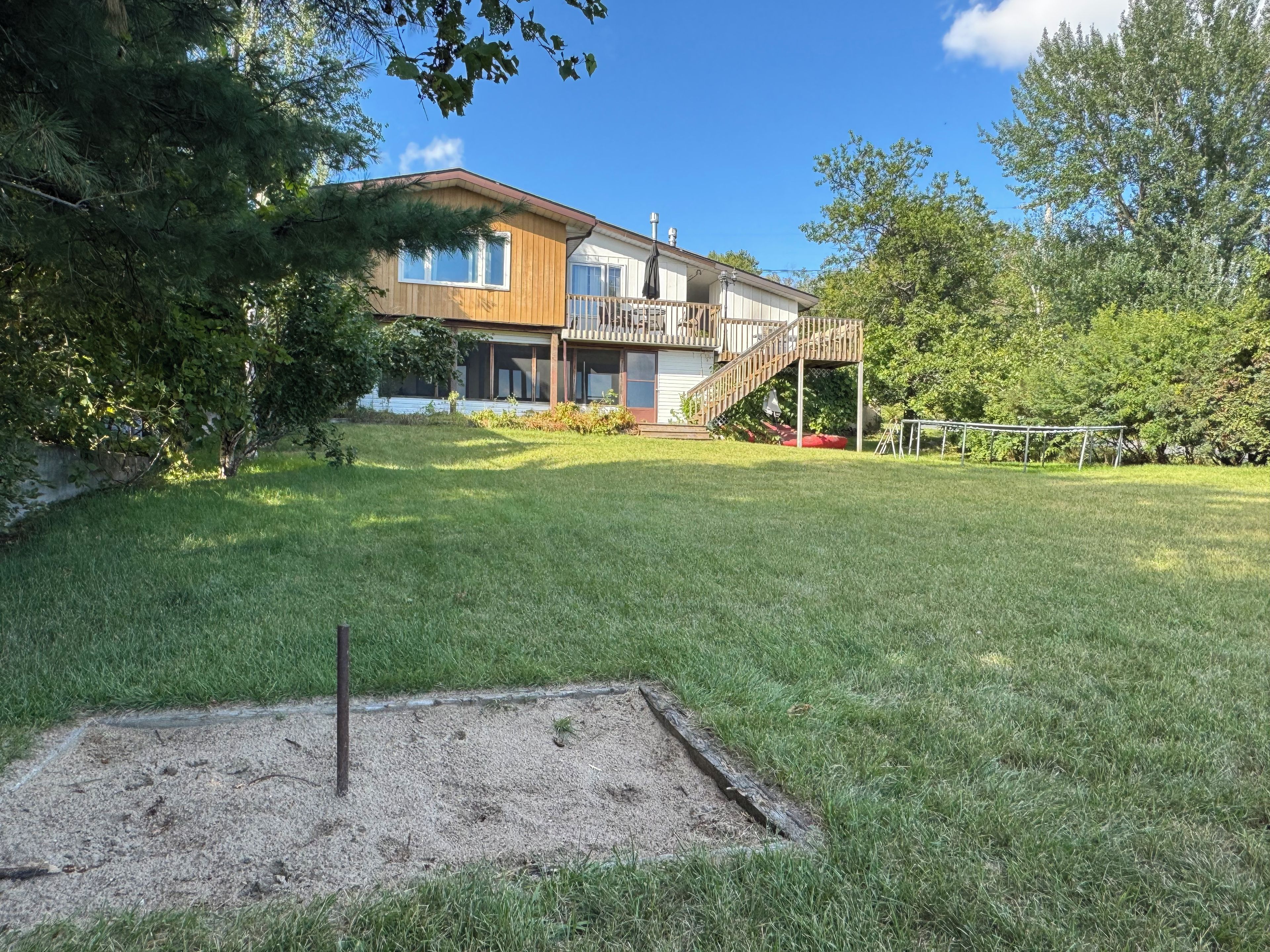 A two-story house with a covered porch and a fenced backyard.