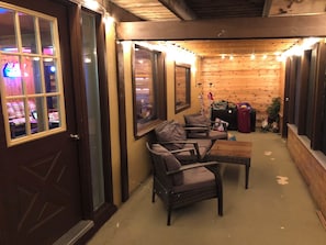 Ein gemütliches Zimmer mit Korbmöbeln, einer Holzbalkendecke und einer Tür zu einem weiteren Bereich.