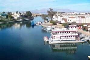Experience tranquil river views from a stationary paddle steamer docked at a scenic pier.