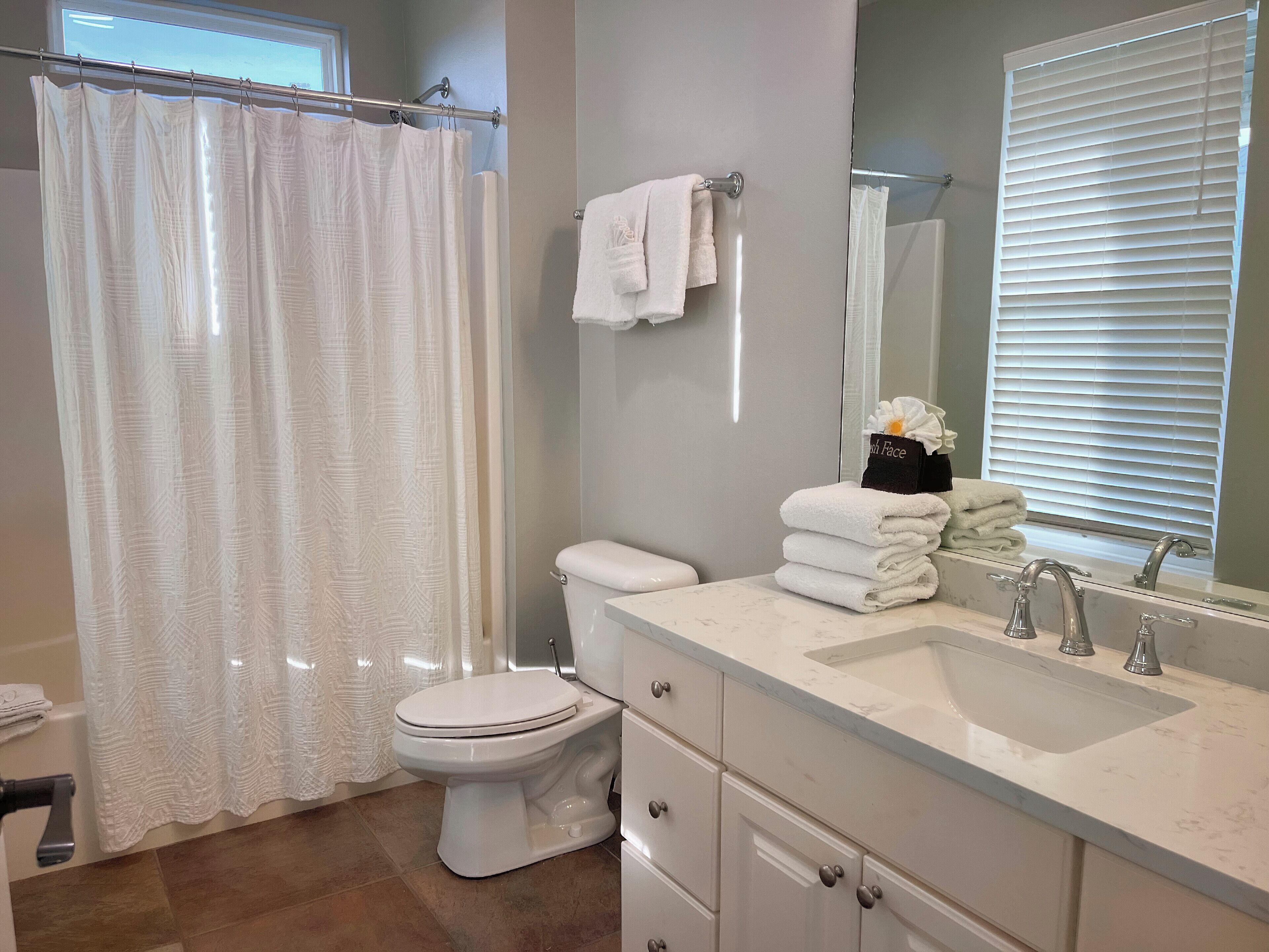 A bathroom with a toilet, sink, and a shower curtain.