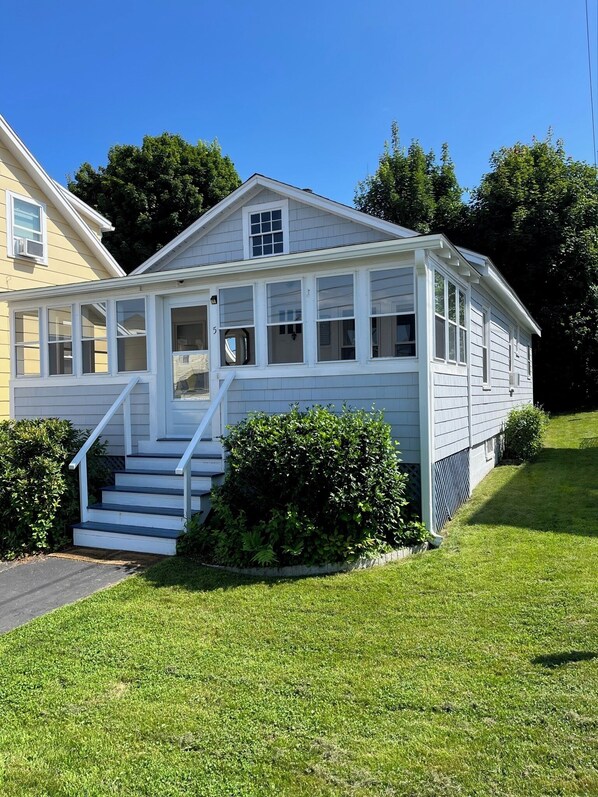 Une maison à deux étages dotée d’un porche abrité et d’un escalier menant à l’entrée.
