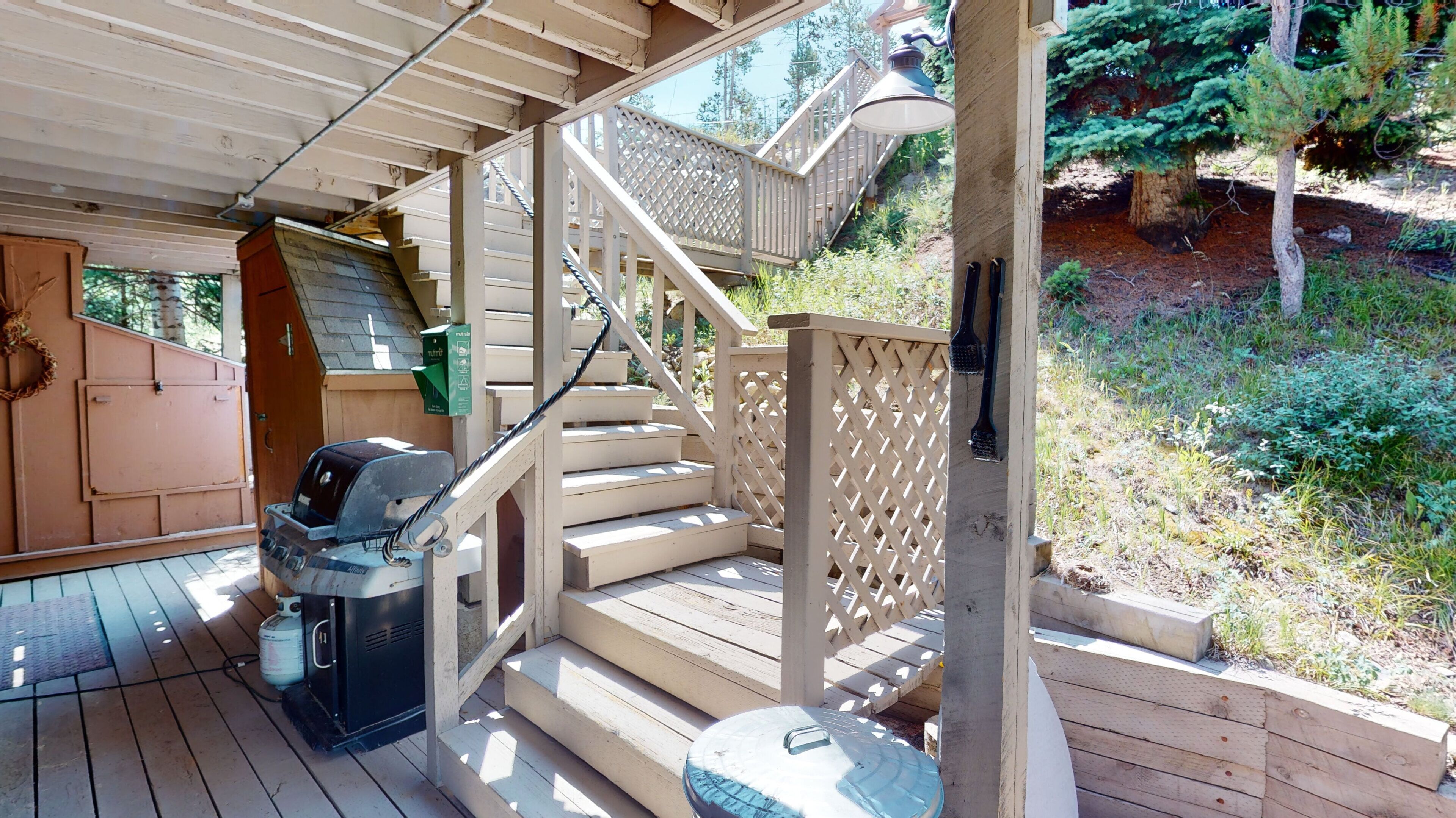 A wooden deck with a barbecue grill and a gas canister.