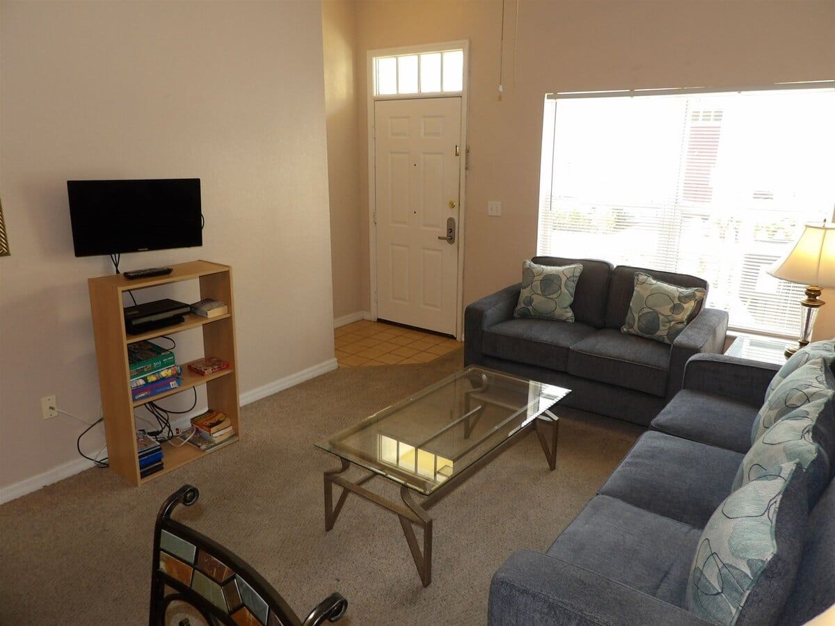 A living room with a sofa, a coffee table, a TV, and a bookshelf.