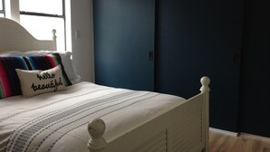 Une chambre à coucher avec un lit, une fenêtre et une porte.
