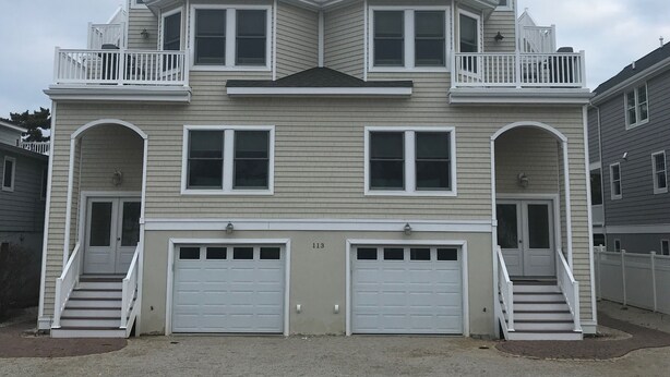 A two-story house with a front garage, a balcony on the upper floor, and a small porch.
