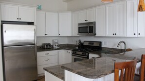 A kitchen with white cabinets, stainless steel appliances, granite countertops, and wooden chairs. - Flexible Good weeks Avail. 6 HOUSES TO BEACH 4 BR 3.5Bath,PingPong,Beach Badges (Long Beach Township)