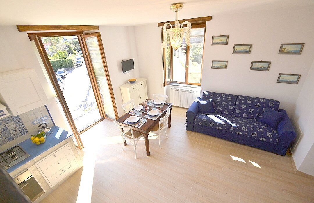 A compact living space with a dining area, kitchenette, and a sofa.
