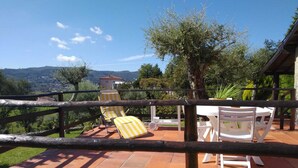Una terraza con mesas al aire libre, vistas al campo y una valla de madera.