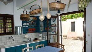 A kitchen with teal cabinets, a blue table, and hanging baskets. - Country villa with amazing view, close to important sites and beaches. (Korinthia)