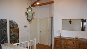 A room with a wooden staircase, a white door, a wooden dresser, and a hanging lantern. - Country villa with amazing view, close to important sites and beaches. (Korinthia)