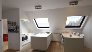 A modern kitchen with skylights, white cabinetry, and a central island with a sink. - 2 Bedroom apartment near center Ghent (Gent)