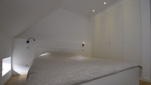 A bedroom with a large bed, a closet, and two wall-mounted lights. - 2 Bedroom apartment near center Ghent (Gent)